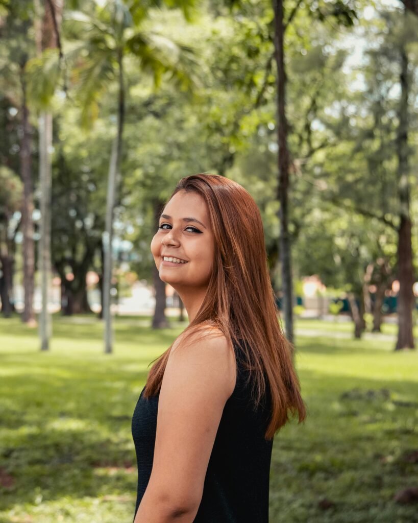 Portrait of a smiling woman outdoors in a lush São Paulo park.